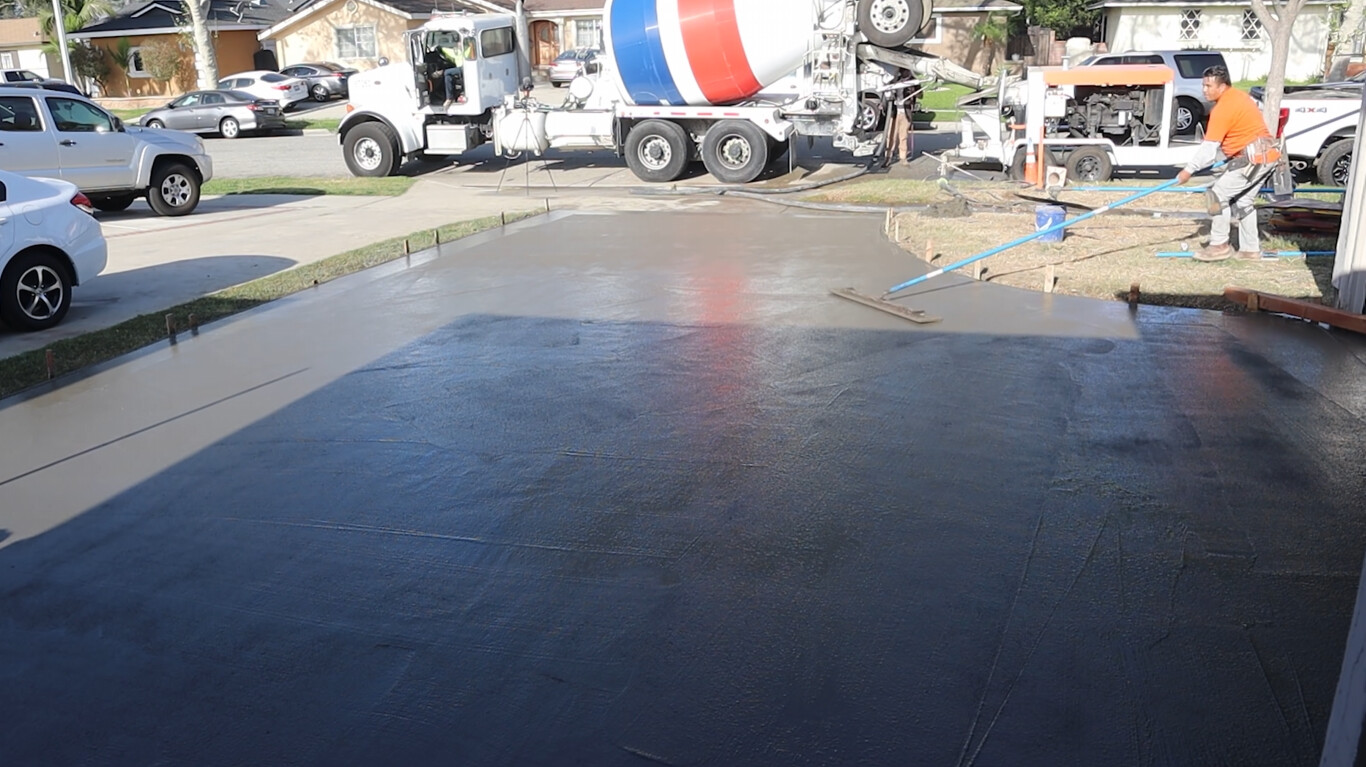 Professional concrete contractor team pouring driveway in Rialto, CA